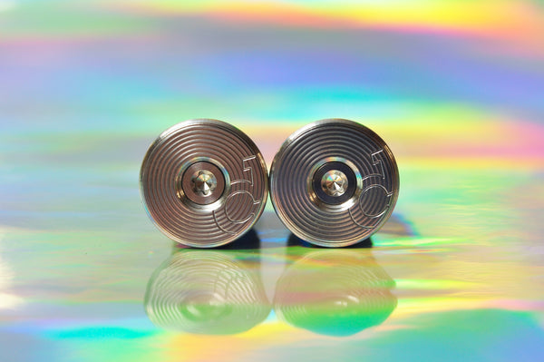 Sturdy titanium bar end plugs, pair, on an iridescent background