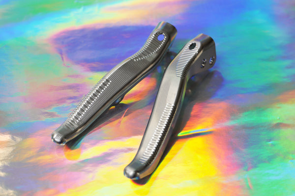 Pair of Sturdy titanium brake levers for SRAM E1 on an iridescent background