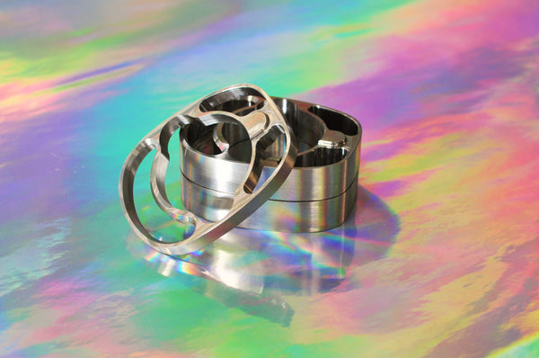 Sturdy titanium headset hardware: spacers and top cap on an iridescent background