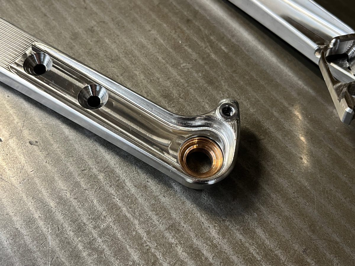 Inside face of a machined titanium rear dropout with countersunk bolt holes