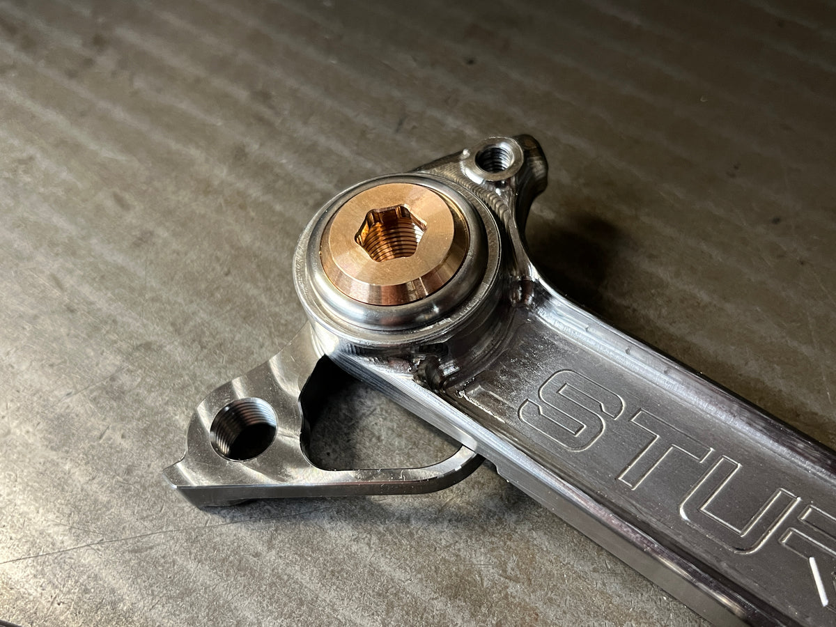Titanium rear dropout with derailleur hanger fitted and a phosphor bronze axle insert