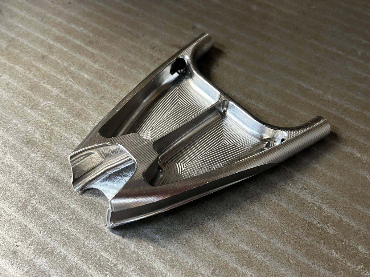 Titanium seat stay yoke at an angle, showing its pocketed underside