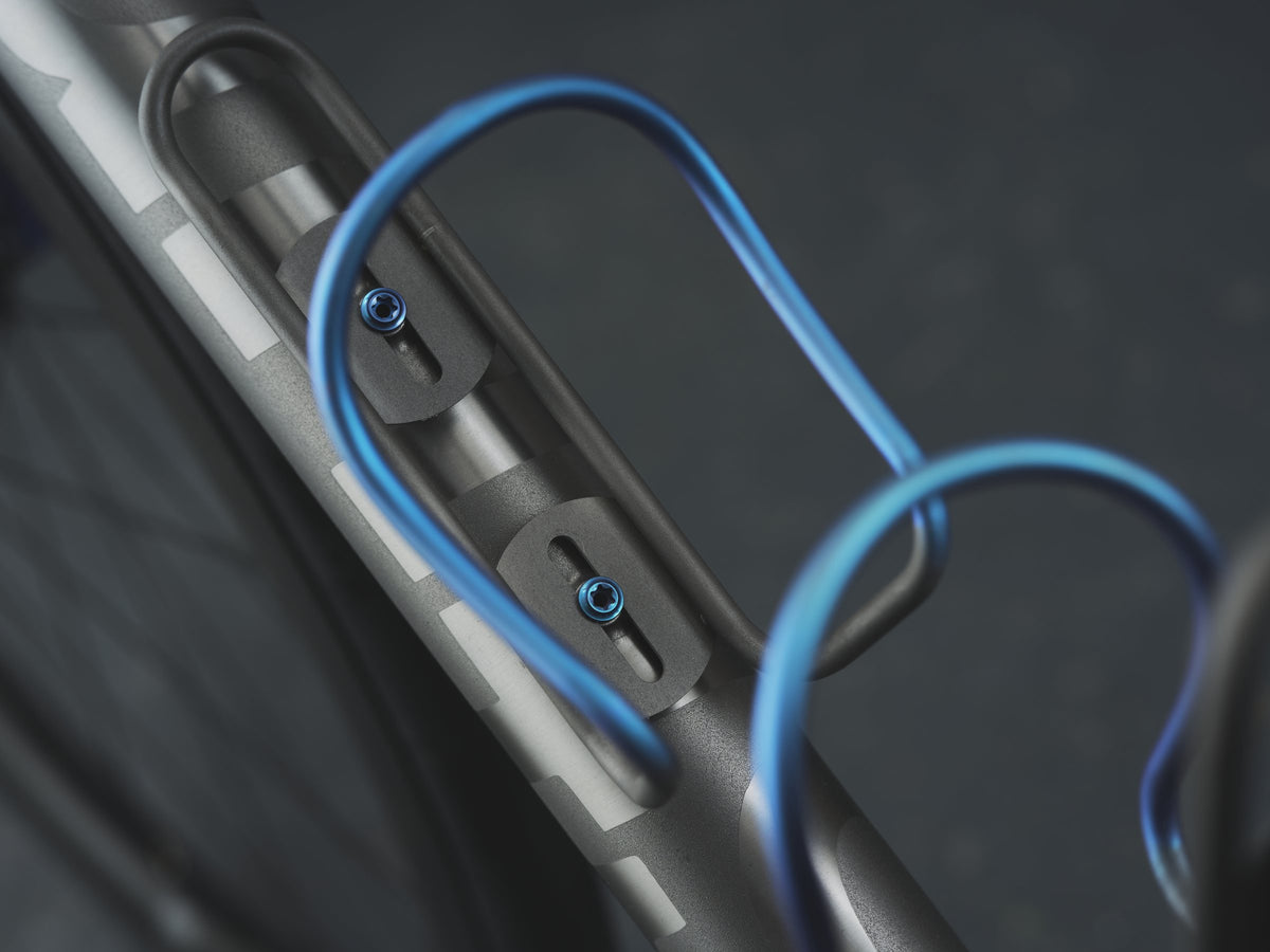 Blue anodised titanium bottle cages and bolts on a shot-peened titanium down tube with grey graphics