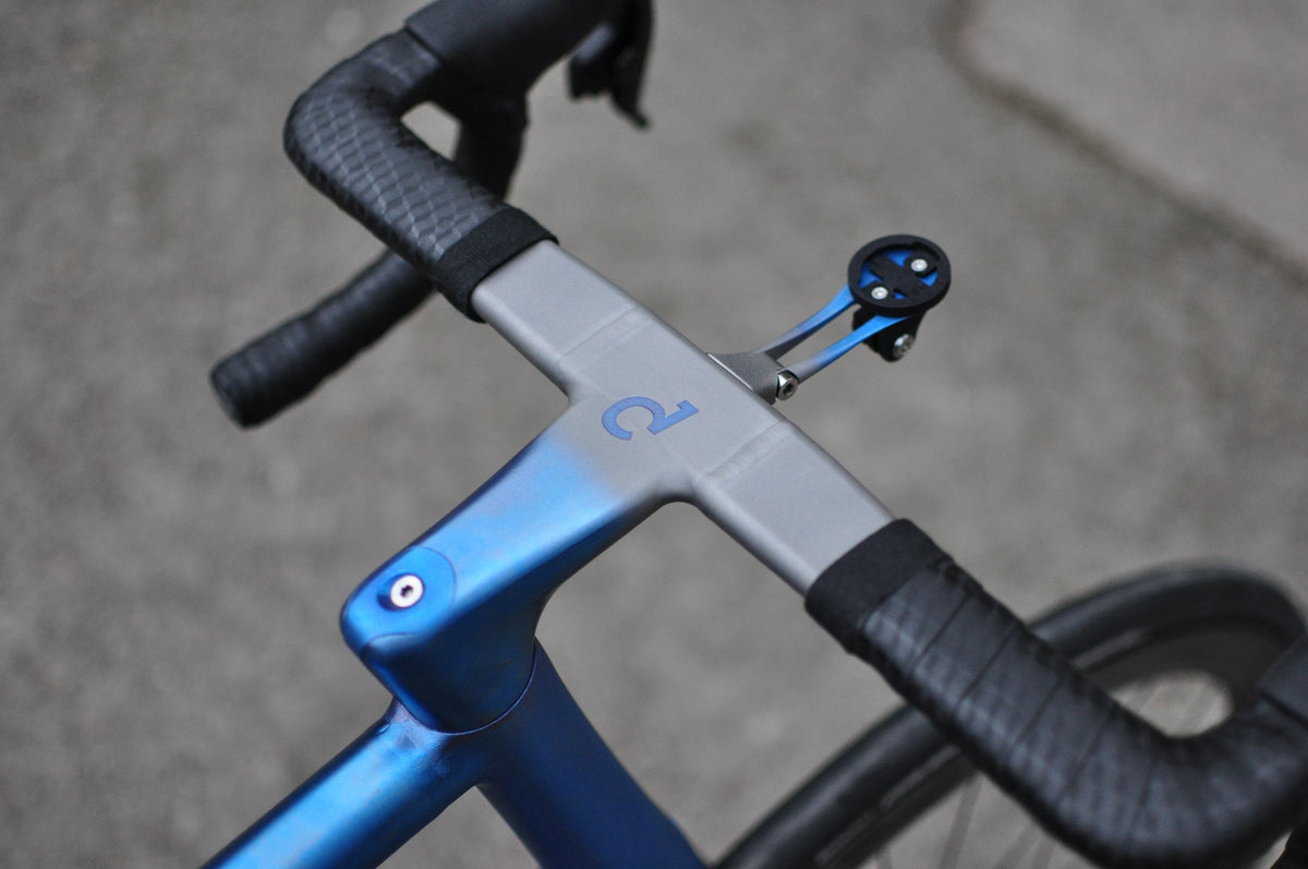Titanium one-piece bar and stem with blue anodised fade, blue Sturdy logo and computer mount