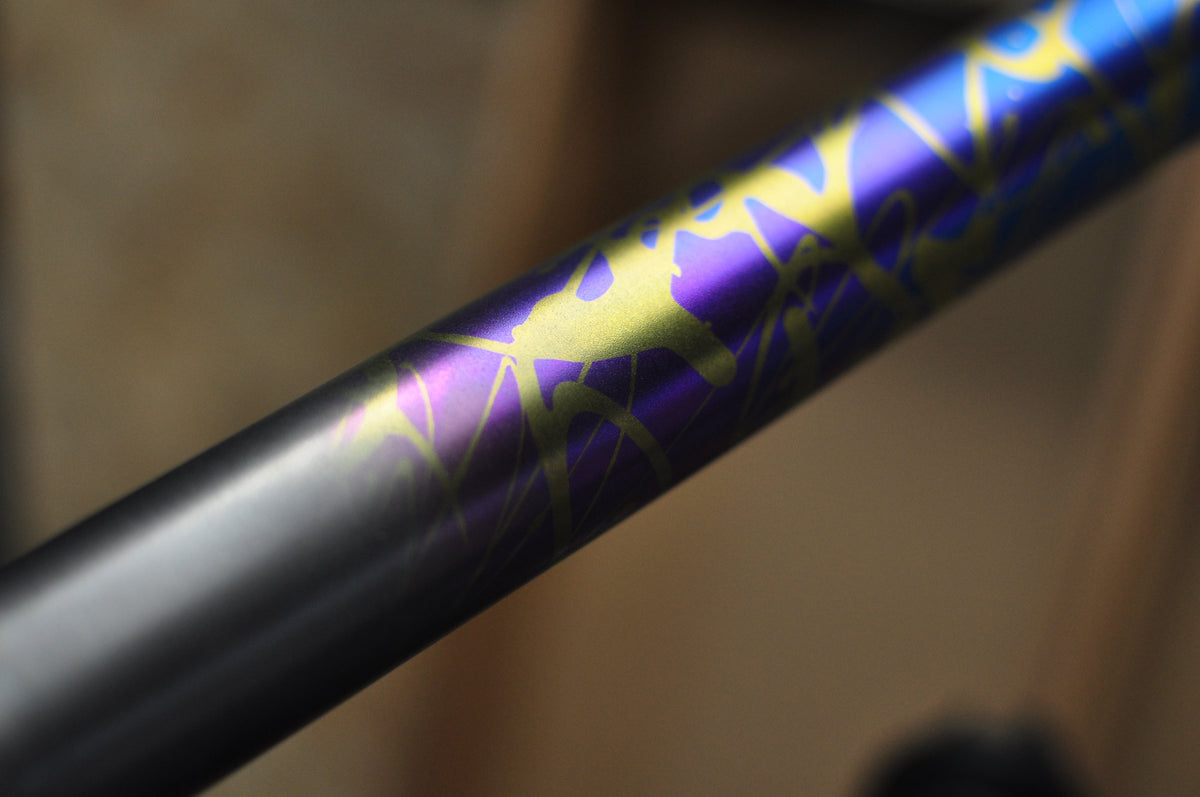Titanium tube fading into purple and blue anodising with gold splatter pattern