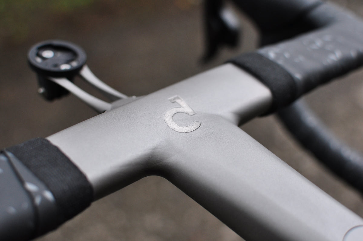 Shot-peened titanium integrated stem and handlebar with polished logo and computer mount
