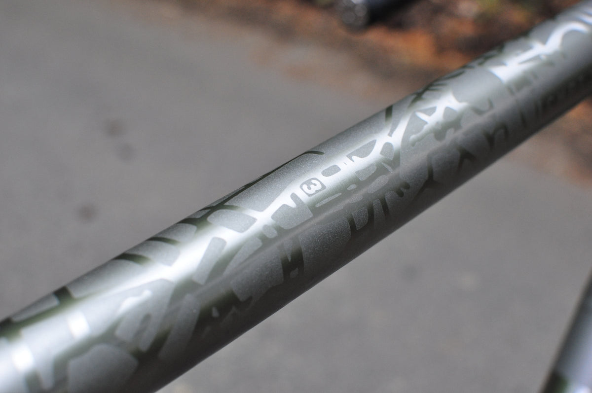 Titanium top tube with tonal etched graphic pattern in polished and matt finishes