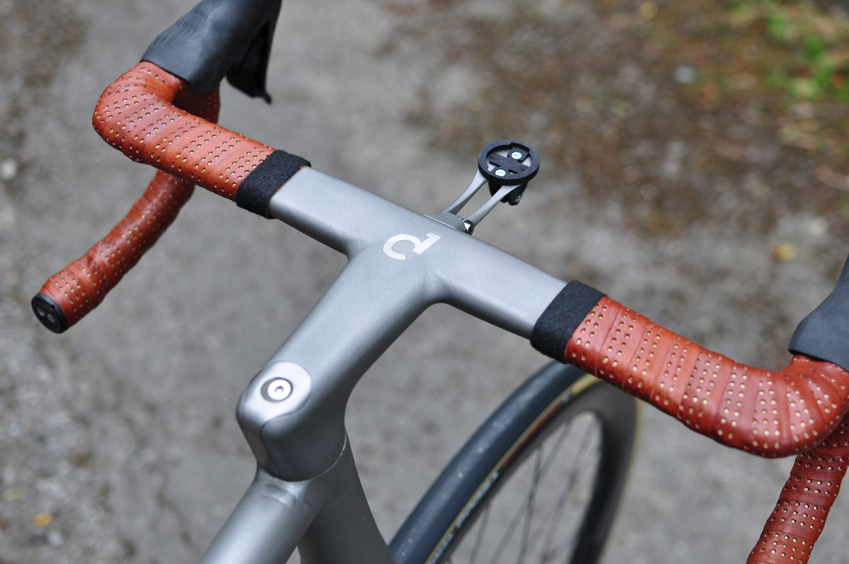Titanium integrated handlebar with etched logo and perforated brown leather bar tape