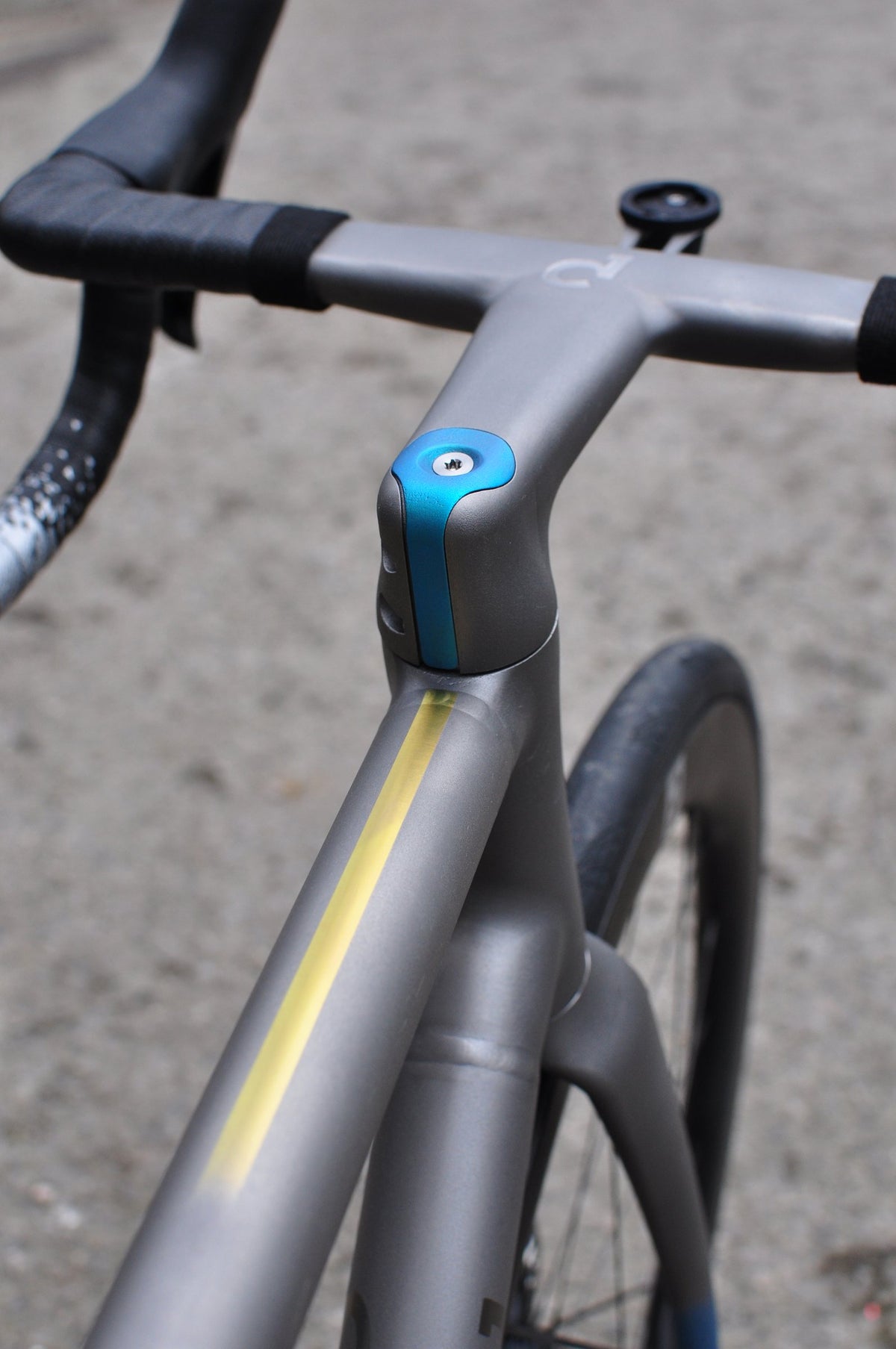 Titanium cockpit with blue anodised stem cap and a yellow stripe along the top tube