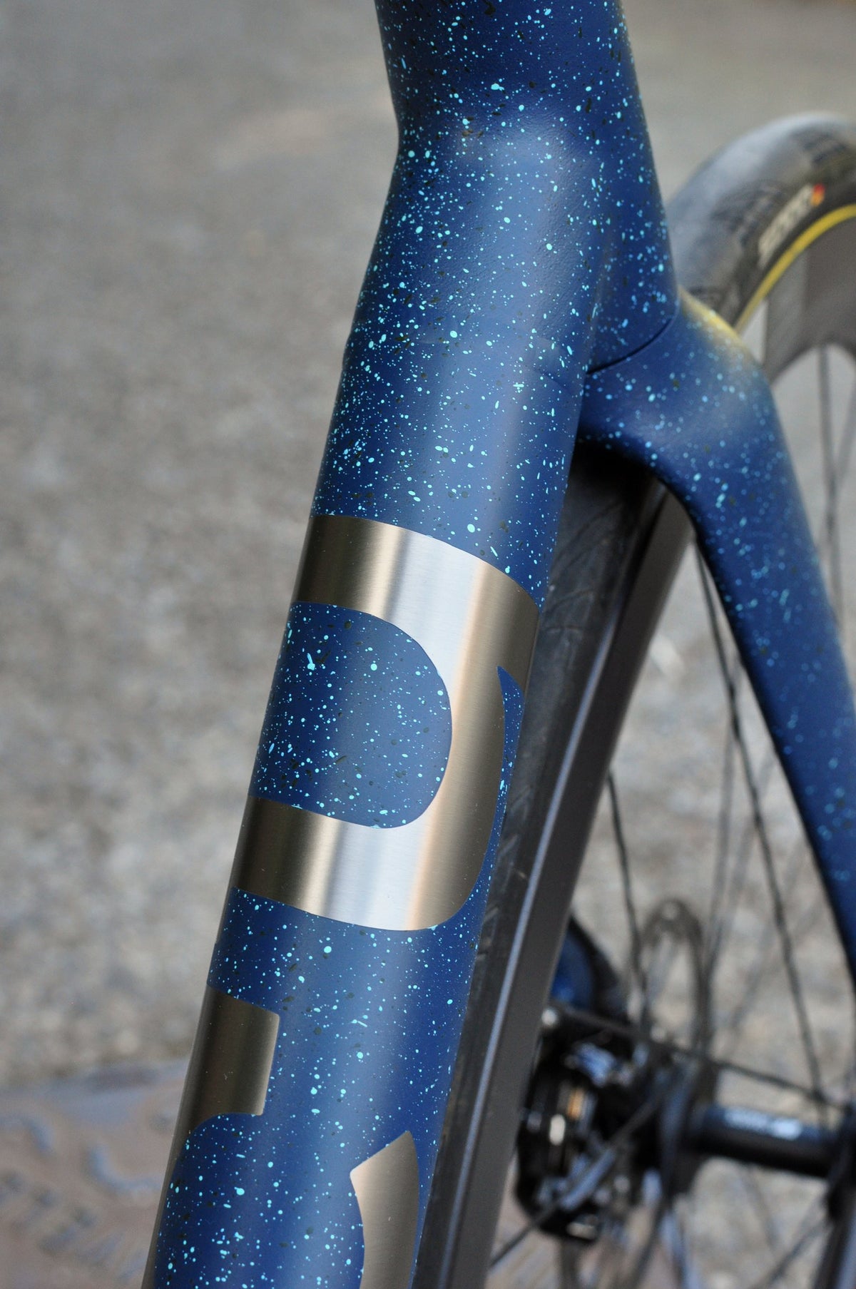 Navy paint with light blue speckles and large brushed titanium lettering on the down tube and fork