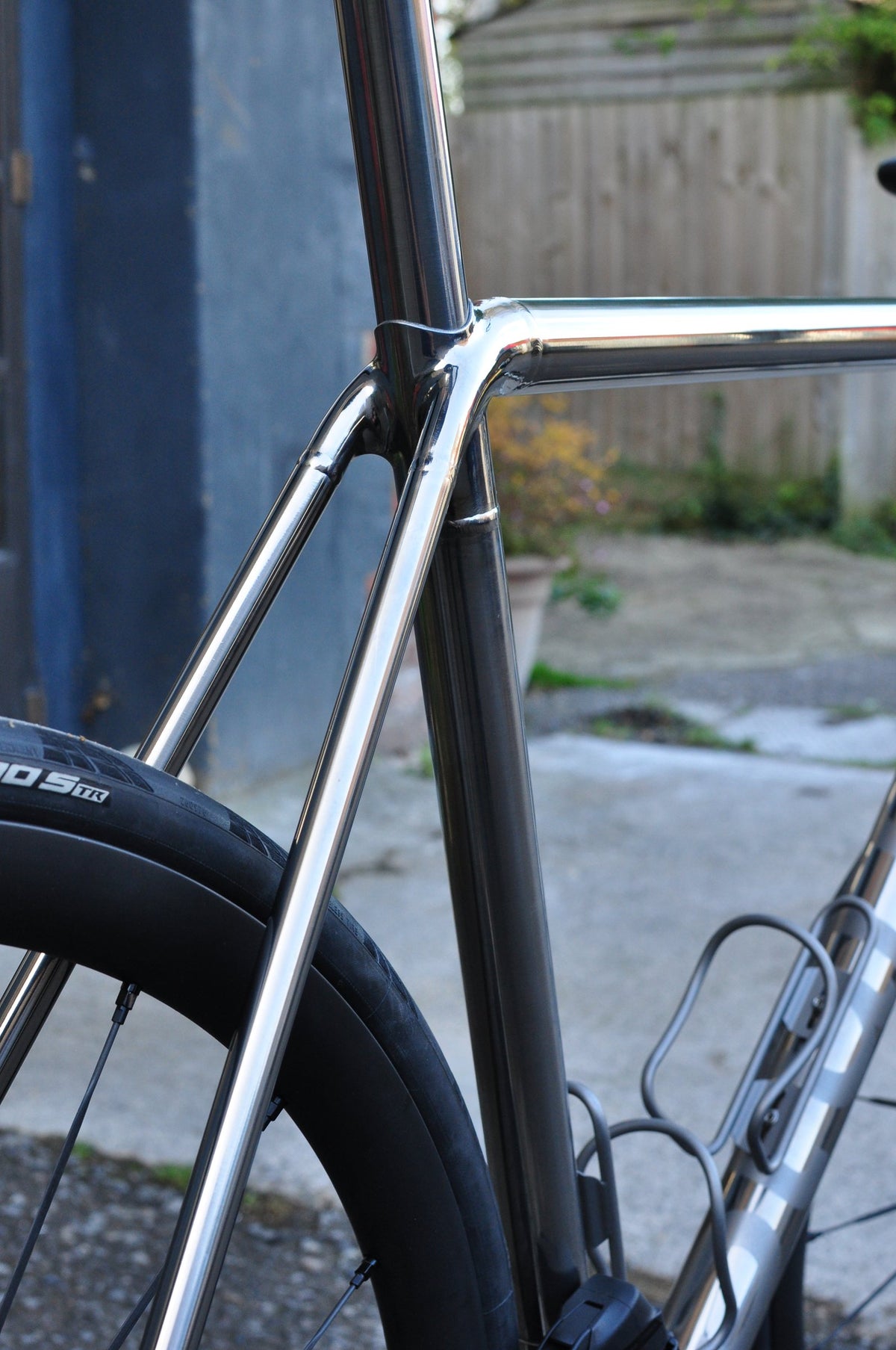 Polished mirror-finish titanium seat cluster and seat stays beside a black road wheel
