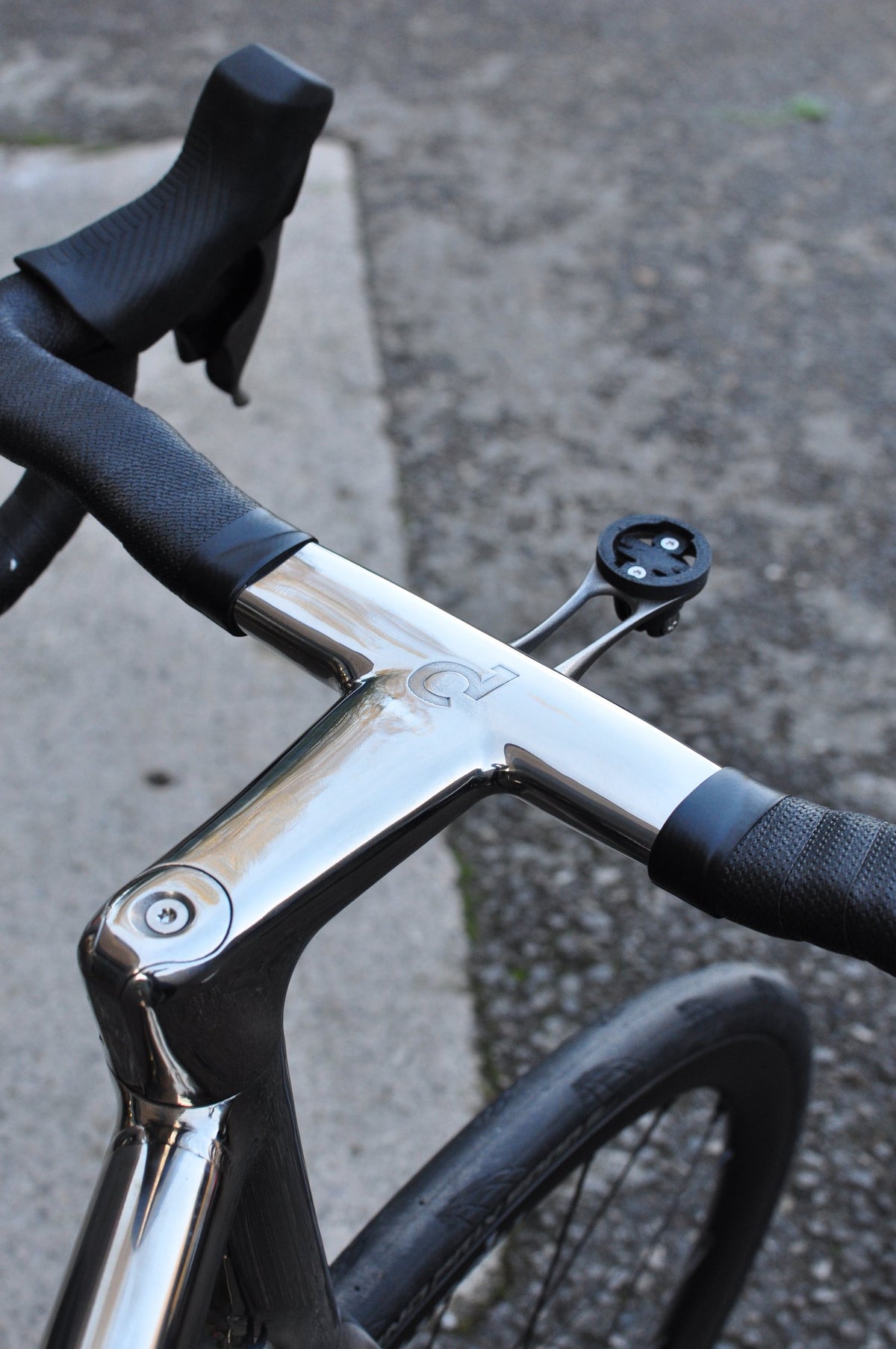 Polished mirror-finish titanium one-piece bar and stem with Sturdy logo and computer mount
