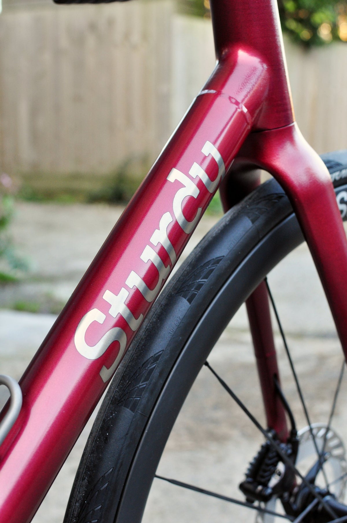 Metallic red down tube with large white Sturdy lettering beside the front wheel