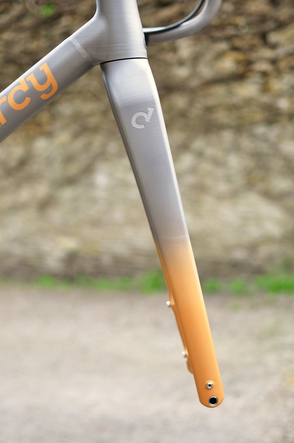 Brushed titanium fork fading to orange at the tip, with orange Sturdy lettering on the down tube