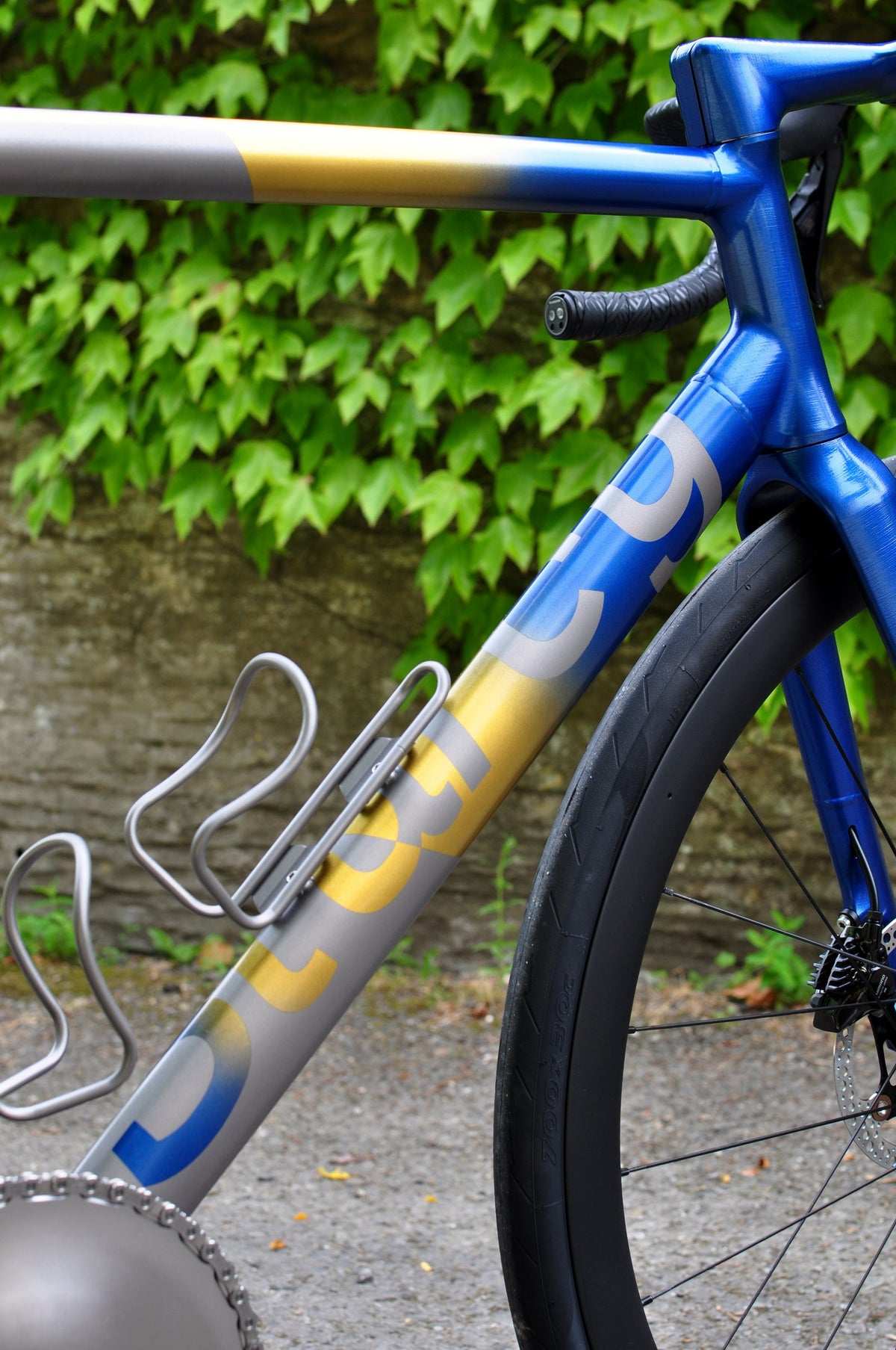 Blue and gold fade paint on titanium top tube and down tube with titanium bottle cages