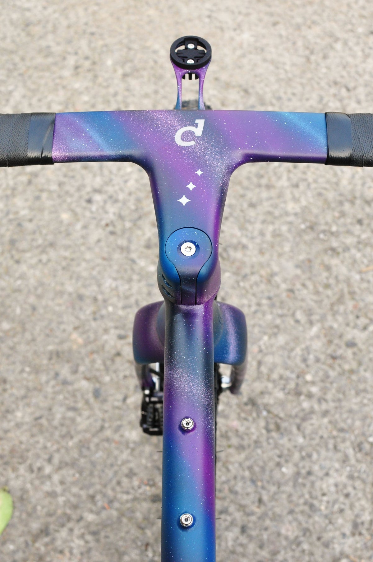 Integrated handlebar and top tube in purple and blue galaxy paint with star motifs, seen from above