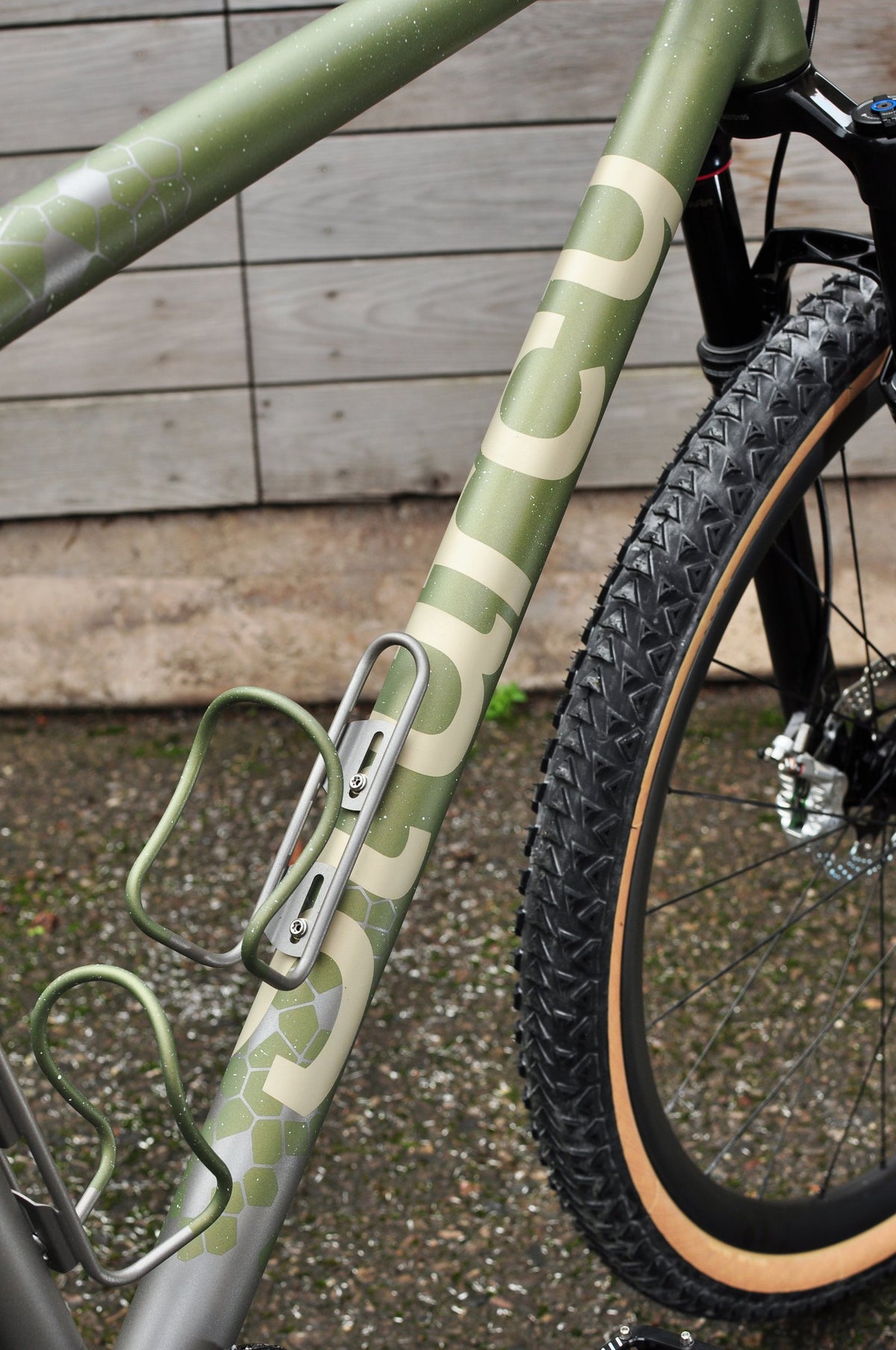 Olive green down tube with cream Sturdy lettering, hexagon pattern and green bottle cages