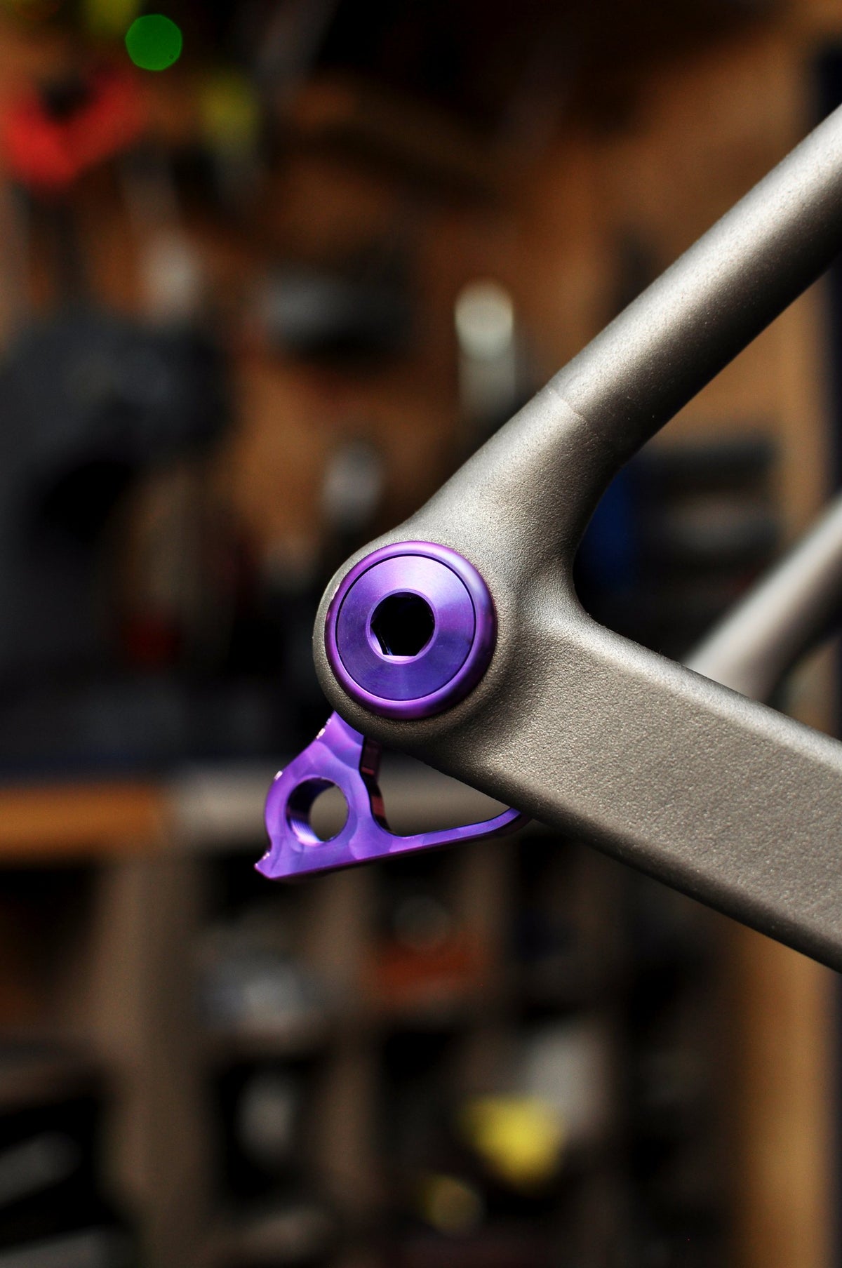 Shot-peened titanium dropout with purple anodised axle insert and hanger in the workshop