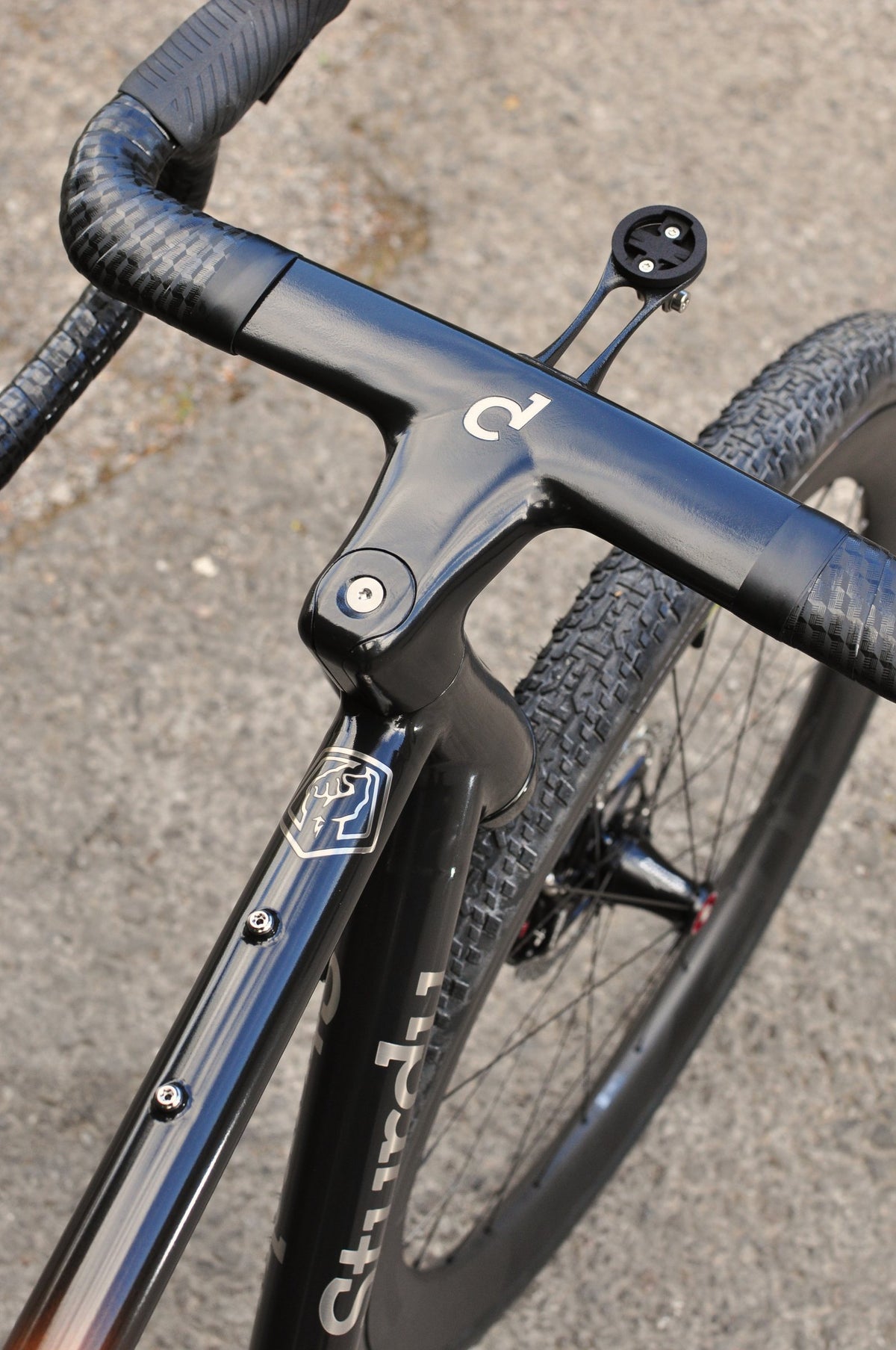 Gloss black integrated handlebar and stem with white logo and computer mount, viewed from above